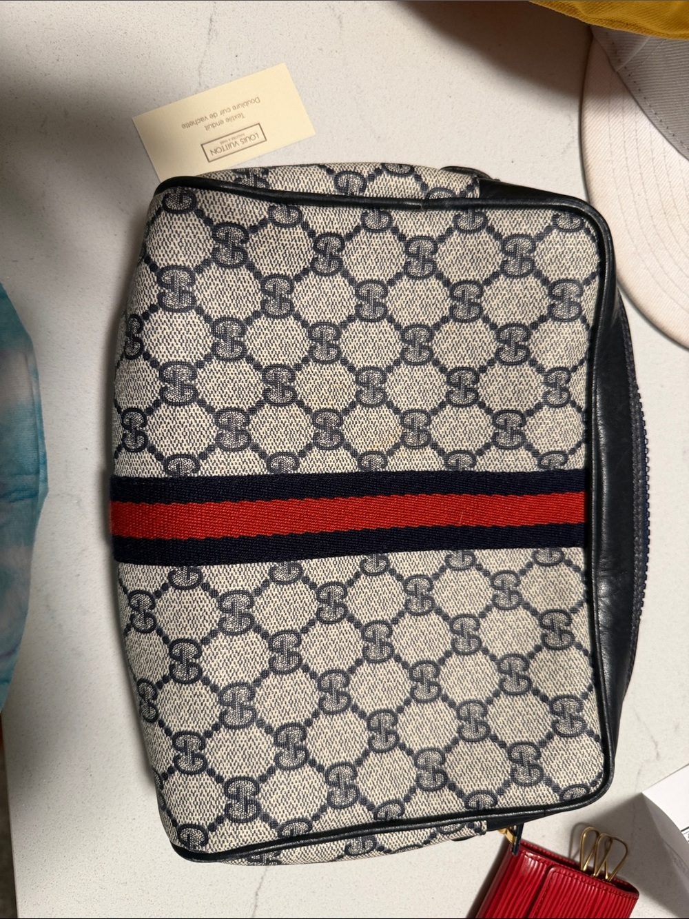 Gucci GG Supreme cosmetic/toiletry bag with the navy-and-red Web stripe.